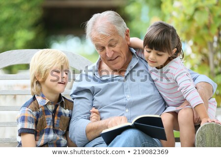 ストックフォト: Senior Man Reading Book To Boy