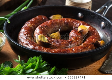 Stok fotoğraf: Fried Sausage In A Frying Pan With Herbs And Spices With Knife A