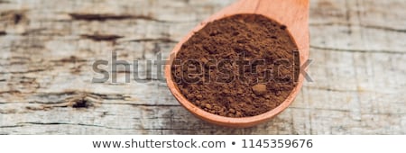 Stock photo: Carob Powder In A Wooden Spoon On An Old Wooden Background