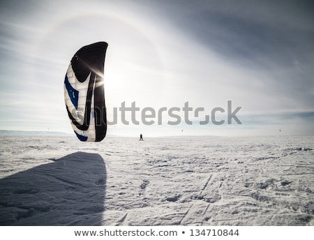 Stock photo: Kiteboarder With Blue Kite On The Snow