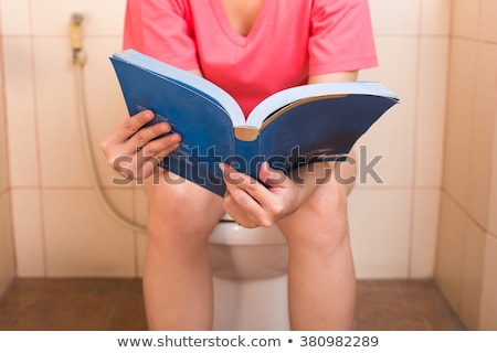 Foto d'archivio: Young Man Reading In The Toilet