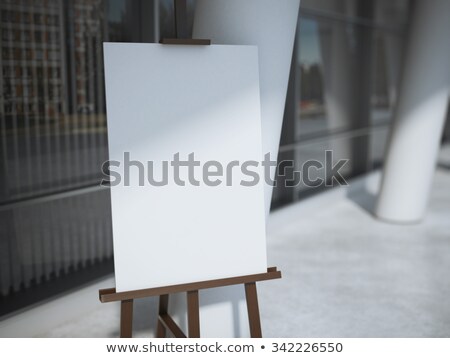 Stockfoto: Wooden Easel With A Blank White Canvas Near Office Building