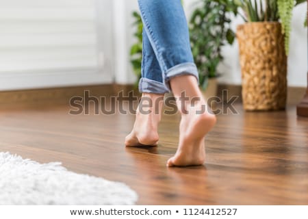 Foto d'archivio: Womans Foot Walking On Hardwood Floor