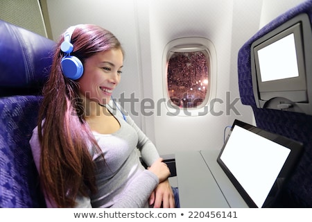 Foto d'archivio: Passenger In Airplane Using Headphones Woman In Plane Cabin Listening To Music On Headphones