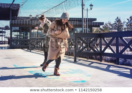 Foto d'archivio: Woman Playing Hopscotch