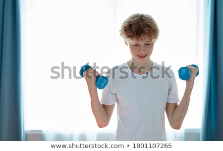 Foto d'archivio: Smiling Redhead With Dumbbells