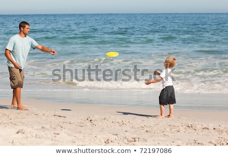 Stock fotó: Boy Playing Frisbee On Beach