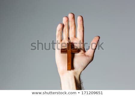 Foto stock: Male Hand Holding Wooden Cross On Gray Background