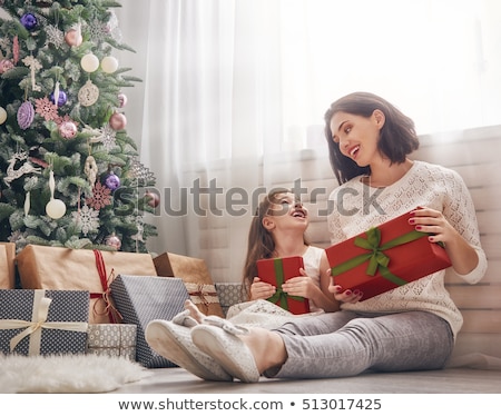 Stockfoto: Mother And Her Little Daughter By The Christmas Decoration