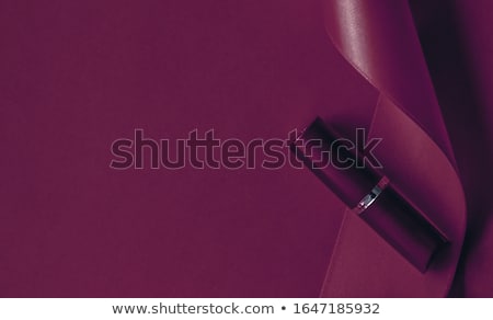Foto d'archivio: Luxury Lipstick And Silk Ribbon On Plum Holiday Background Make