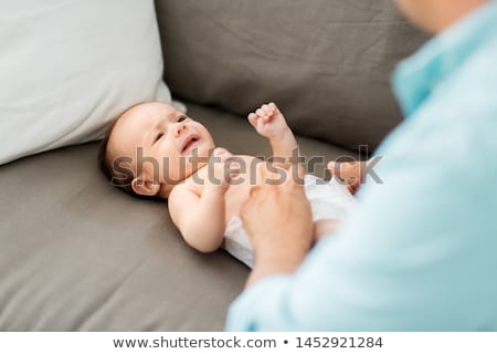 ストックフォト: Middle Aged Father Changing Babys Diaper At Home