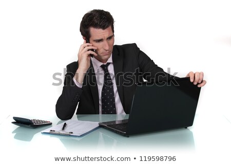 Сток-фото: Businessman Making Call Whilst Reading From Computer Screen