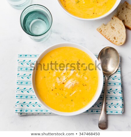 Foto d'archivio: Pumpkin And Coconut Soup With Chicken On White Stone Background