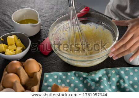Foto stock: Woman Whisking Batter Of Beaten Eggs And Milk In A Bowl
