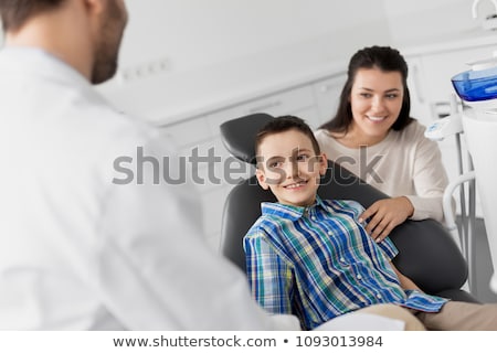 Stockfoto: Mother And Son Visiting Dentist At Dental Clinic