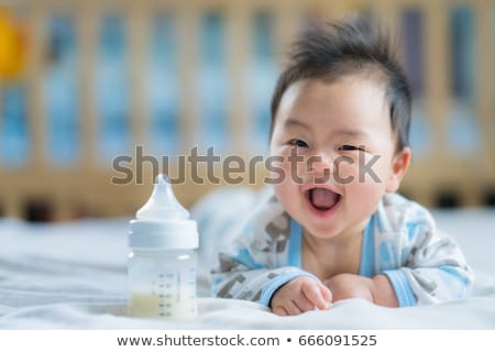 Stock foto: Mother With Young Baby And Bottle On Bed