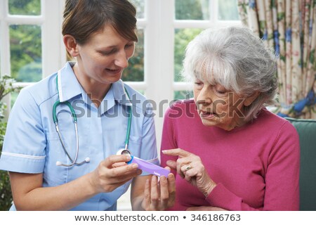 Foto stock: Nurse Advising Senior Woman On Medication At Home