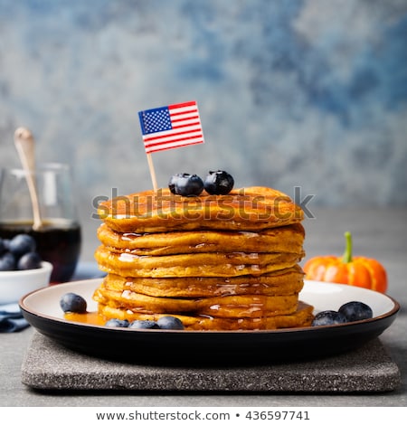Stockfoto: Pumpkin Pancakes With Maple Syrup And Blueberries On A Plate With American Flag On Top