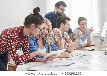 Foto d'archivio: Business Colleagues Discussing Over Blueprint