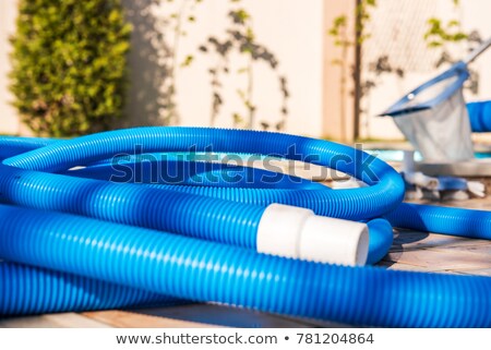 Foto stock: Pool Vacuum Cleaning Flexible Hose On The Pool