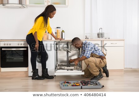 ストックフォト: Woman Looking At Repairman Repairing Dishwasher In Kitchen