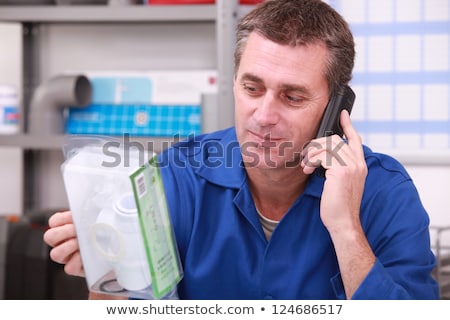 Stock fotó: Man On Telephone Checking A Plumbing Part