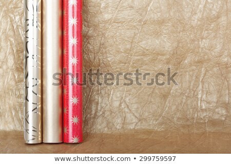 Foto stock: Rolls Of Multicolored Wrapping Paper For Gifts On Gold Backgroun