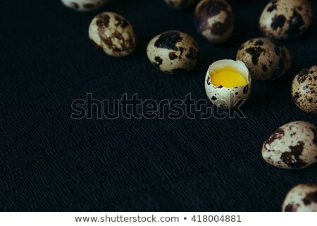 Foto stock: Quail Eggs On A Black Textured Background Raw Broken Egg With The Yolk Easter Card Side View