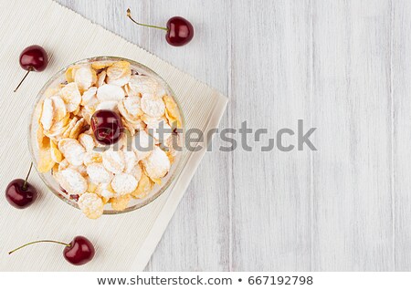 Stockfoto: Sweet Breakfast With Golden Corn Flakes Ripe Cherries Powdered Sugar On White Wood Board