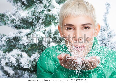 Foto stock: Woman Blowing Snow Through The Camera