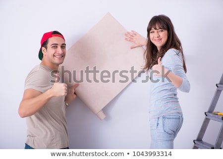 Stock foto: Young Family Doing Renovation At Home With New Wallpaper