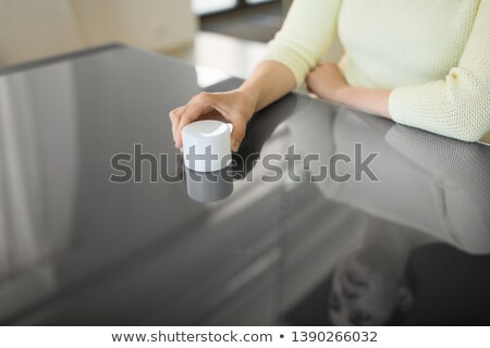 Foto stock: Hand Using Smart Speaker On Interactive Panel