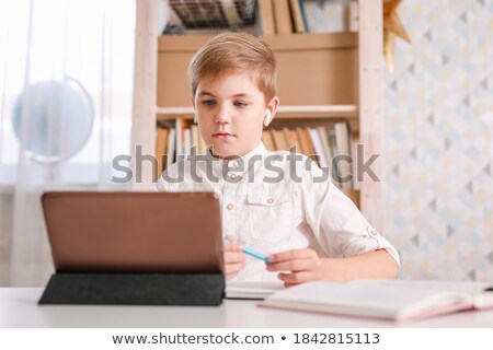 Foto stock: Young Blond Boy Using His Computer Tablet