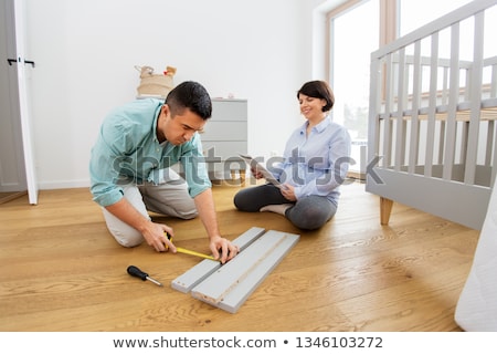 Stock foto: Family Couple With User Manual Assembling Baby Bed