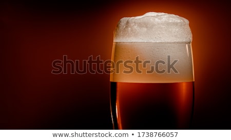 Foto stock: Lager Beer Settles In The Glass With A White Cap Of Foam