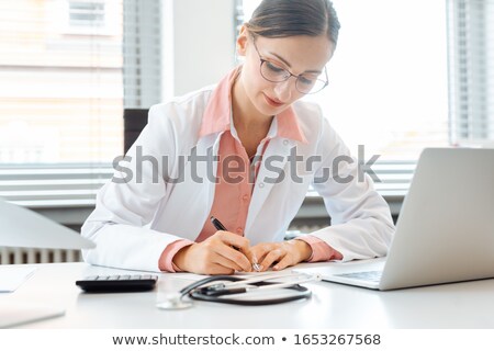 Сток-фото: Doctor Doing Office Works And Administration On The Desk In Her Office