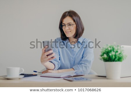 Stock foto: Successful Brunette Female Freelancer Recieves Good News On Smart Phone While Works On Laptop Comput