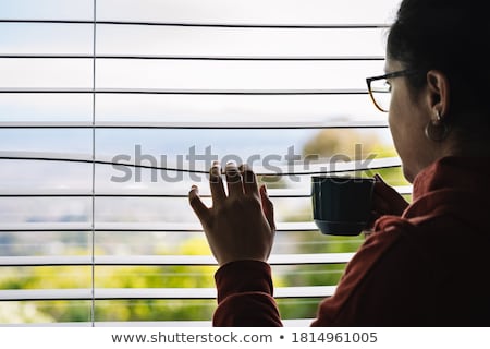 Stockfoto: Woman Looking Through Blinds