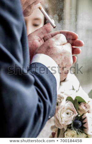 Zdjęcia stock: Fashion Man Looking Down While Holding A Cigarette