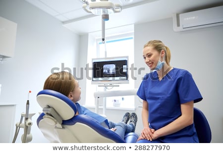 Stok fotoğraf: Dentist Talking To Kid Patient At Dental Clinic