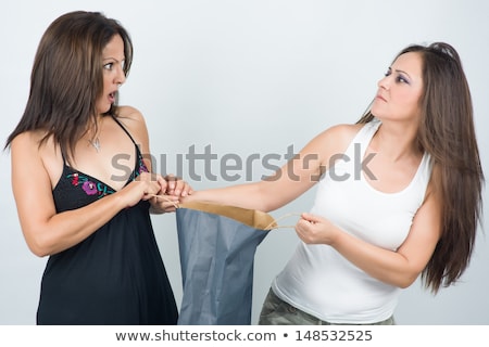 Foto d'archivio: Two Women Fighting Over Shopping Bag With Furious Expressions