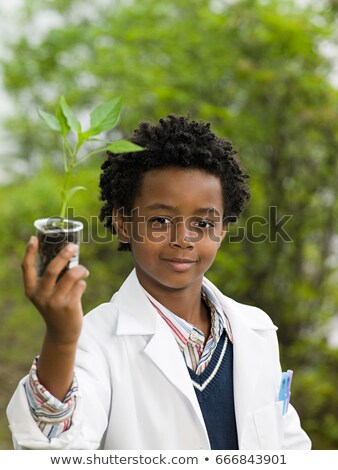 Stock photo: A Boy Holding A Plant In A Volumetric Flask