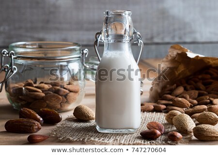 Foto stock: A Bottle Of Almond Milk With Almonds And Dates