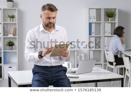 Foto d'archivio: Serious Employer In Formalwear Using Touchpad While Surfing In The Net