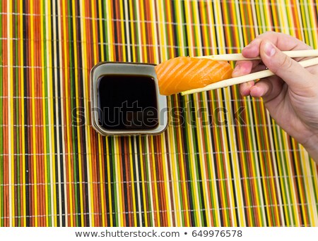 Foto stock: Hand Holding Japanese Sushi Bamboo Napkin In Background