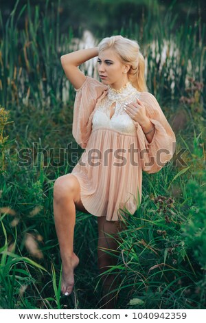 Foto stock: Young Pretty Woman In Pink Dress Among Reed