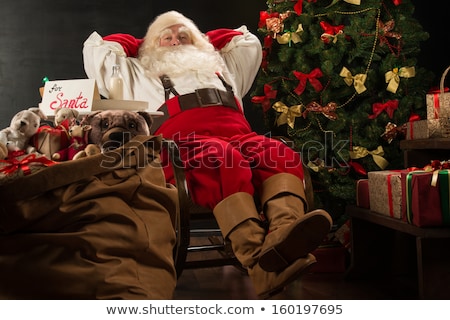 Zdjęcia stock: Santa Claus Keeping His Hands Behind Head While Relaxing At Home