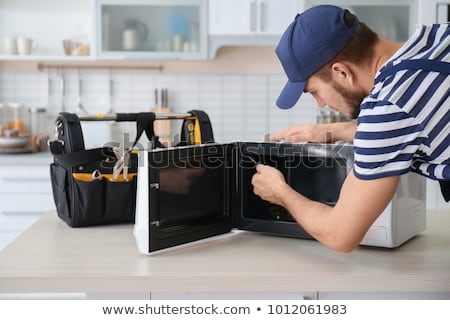 Stockfoto: Man Repairing Microwave Oven