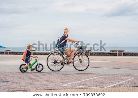 Сток-фото: Happy Family Is Riding Bikes Outdoors And Smiling Mom On A Bike And Son On A Balancebike