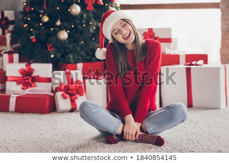 Сток-фото: Charming Woman Wearing Santa Claus Hat Opening Christmas Gift